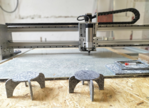 Maquetes de taules davant de màquina de tallar plàstic reciclat